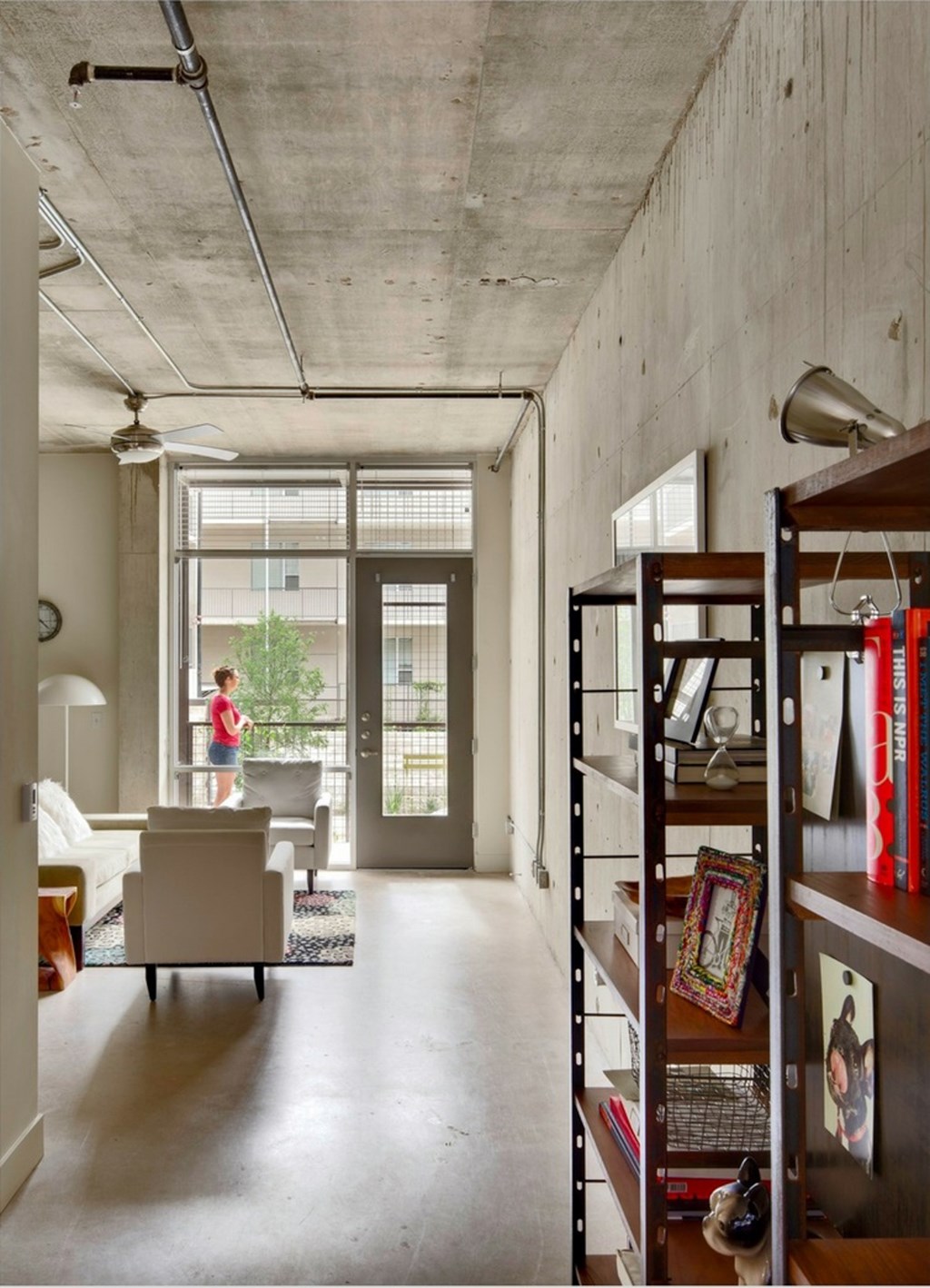 A person stands in a doorway with a plant in the background.