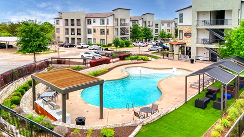 a swimming pool in front of an apartment building at Radius on Grove, Austin, 78741