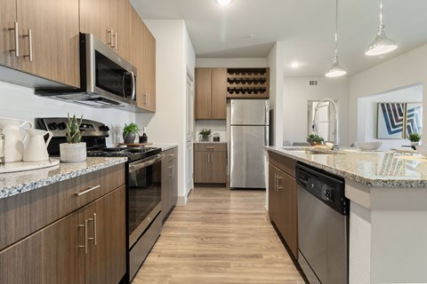 A modern kitchen with wooden cabinets and stainless steel appliances.
