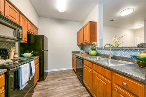A kitchen with wooden cabinets and black appliances.