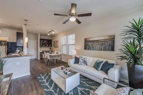 A living room with a white couch and a ceiling fan.
