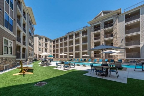 A sunny day at a resort with a pool and lounging area.