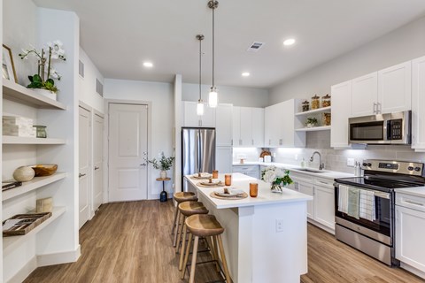 A kitchen with white cabinets and a wooden floor.
