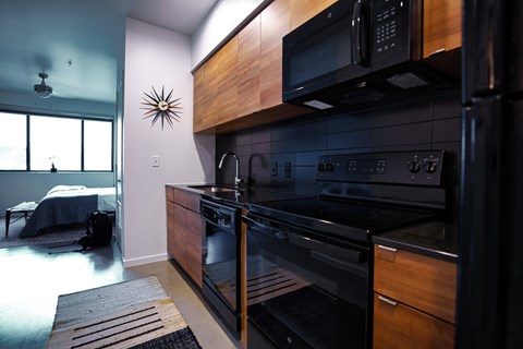 A modern kitchen with a black oven and microwave.