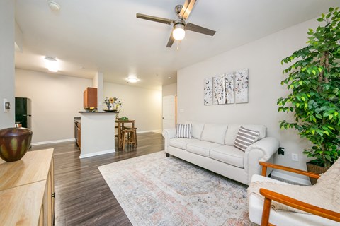 A living room with a white couch and a ceiling fan.