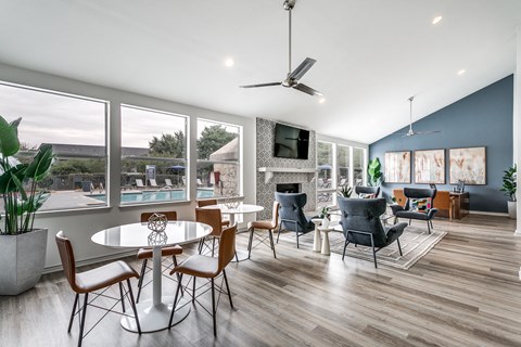 A modern dining room with a table set for six and a television mounted on the wall.