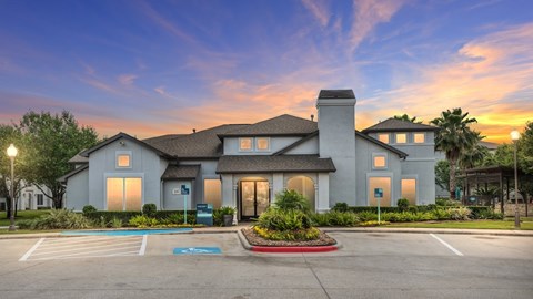 A large, modern house with a spacious driveway in front at Rosemary Apartments, Conroe