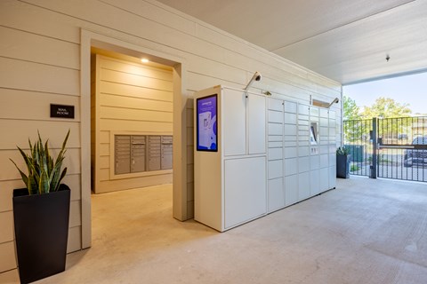 A modern house entrance with a digital screen and a plant.