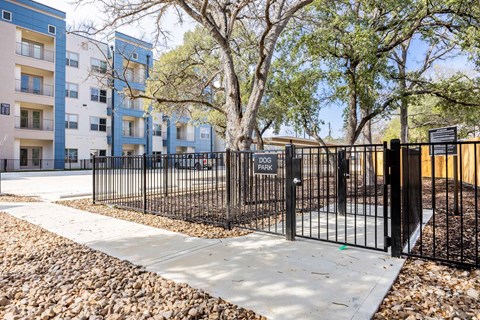Fenced dog park with entry gate at Emilia Apartments, Boerne