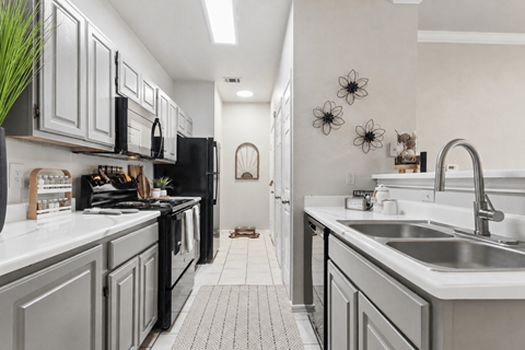 A kitchen with black appliances and white countertops.