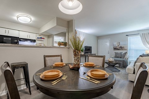 A modern dining room with a round table set for a meal.