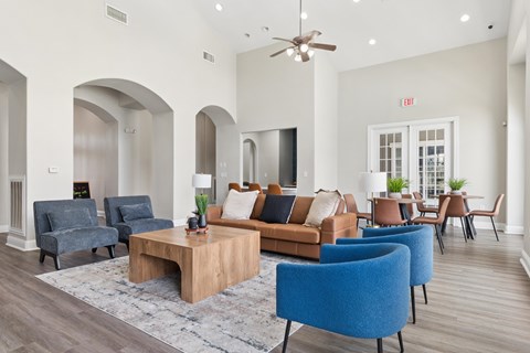 A living room with a blue chair and a brown couch.
