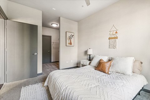 Bedroom with white bedding and wall decor at Lofts on Main Apartments, Texas, 78212