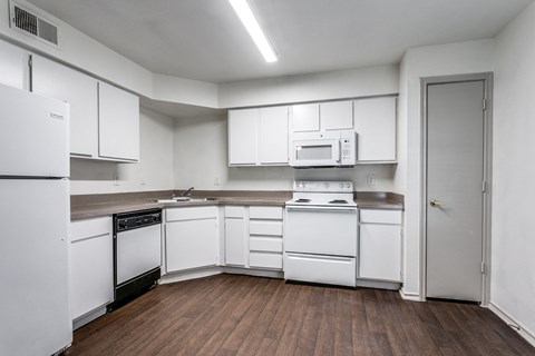 A kitchen with white appliances and cabinets.