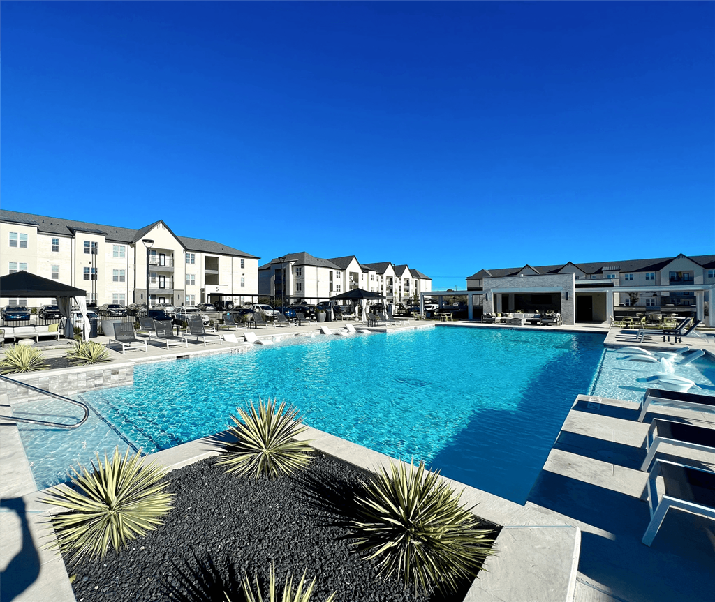 a large swimming pool with buildings in the background a large swimming pool with buildings in the background at The Fitzroy San Marcos, San Marcos, Texas