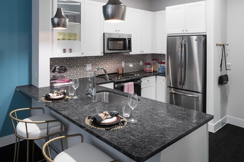 a kitchen with granite counter tops and stainless steel appliances