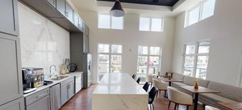 the kitchen and dining area of an open floor plan with a large white counter top at The Fitzroy San Marcos, San Marcos, Texas