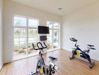 a home gym with exercise bikes and a tv at The Fitzroy San Marcos, San Marcos