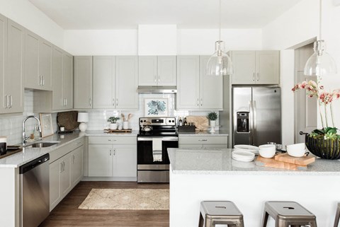A modern kitchen with stainless steel appliances and white cabinets.