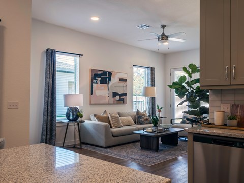 A living room with a couch, a table, and a painting on the wall.