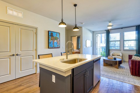 A kitchen with a white counter top and a painting hanging above it.
