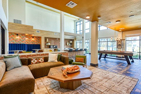A living room with a brown couch and a coffee table.