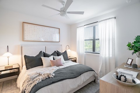 Cozy bedroom with neutral tones and layered bedding at Hangar at Bergstrom Apartments, Texas