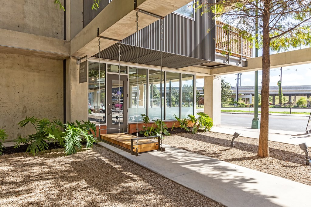 A modern building with a glass entrance and a tree in front.
