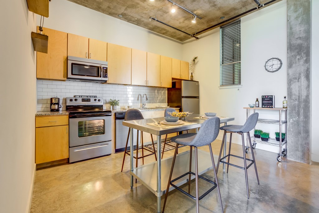 A kitchen with a table and chairs in the middle of it.