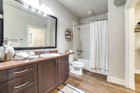 a bathroom with a large mirror and a white shower curtain at The Landings at Brooks City-Base, Texas, 78235