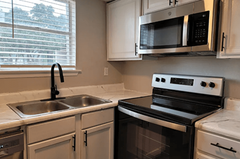 a kitchen with a sink and a stove and a microwave