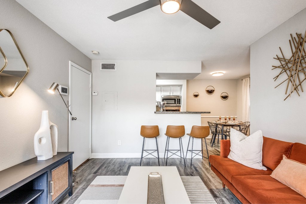 A living room with a couch, chairs, and a bar area.