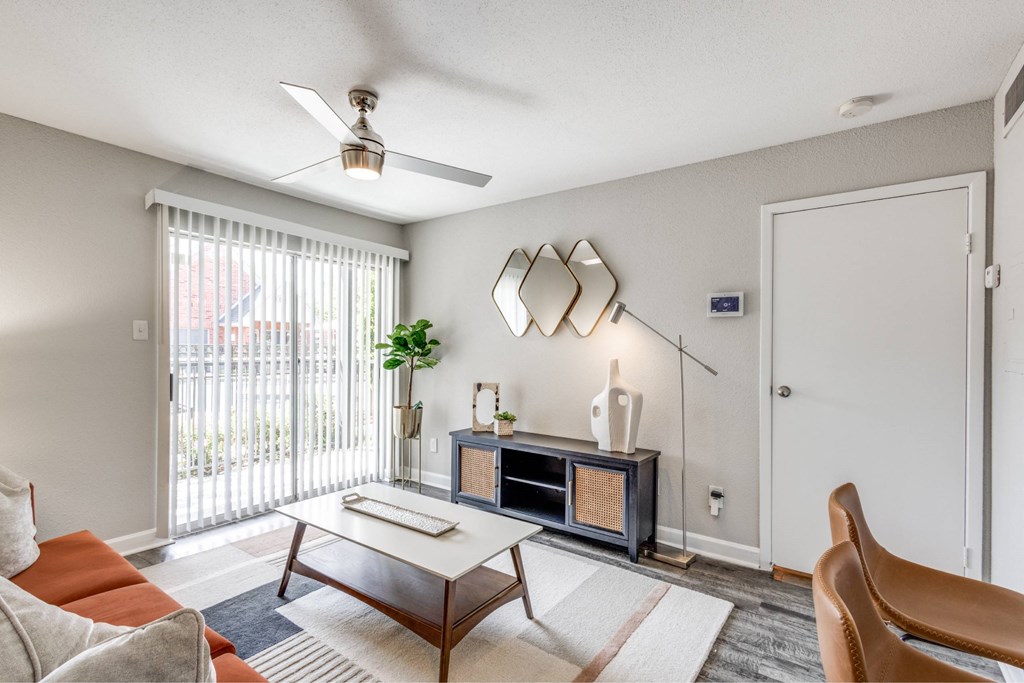 A living room with a brown coffee table and a white sofa.