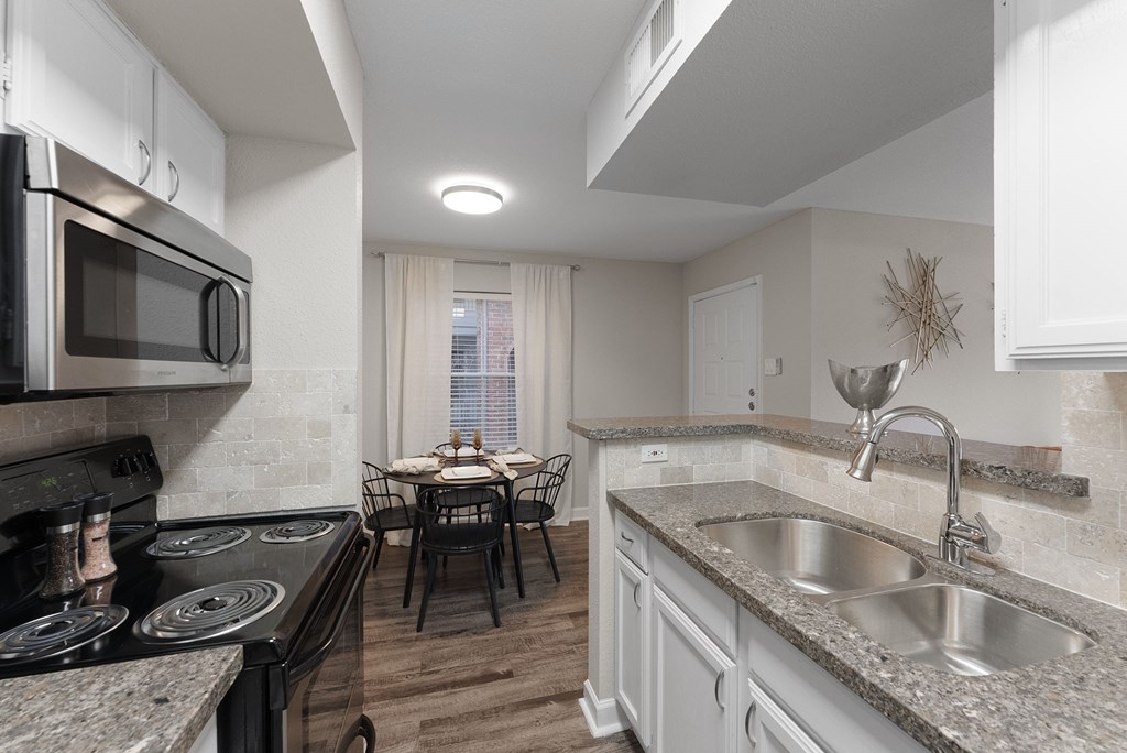 A kitchen with a table and chairs in the middle.
