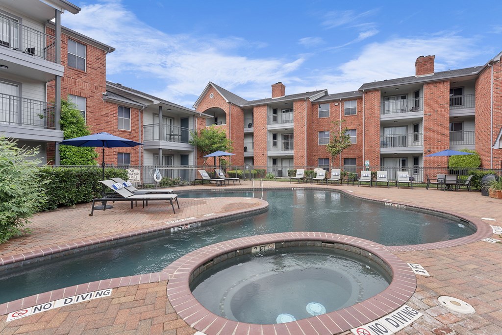 A pool with a sign that says "No Diving" in front of a brick building.