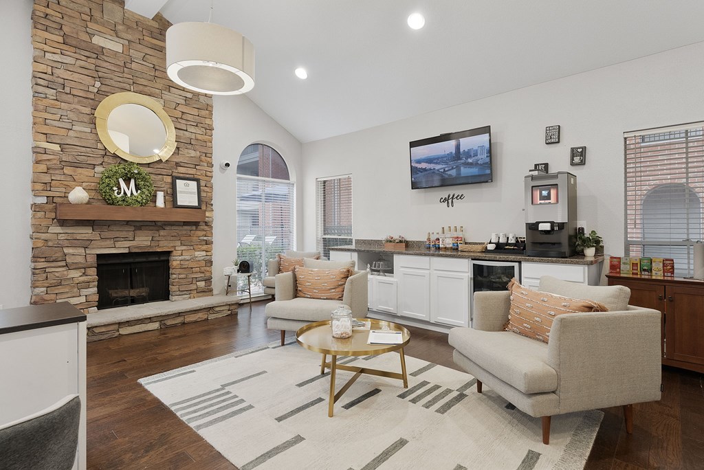 A living room with a stone fireplace and a flat screen TV mounted on the wall.