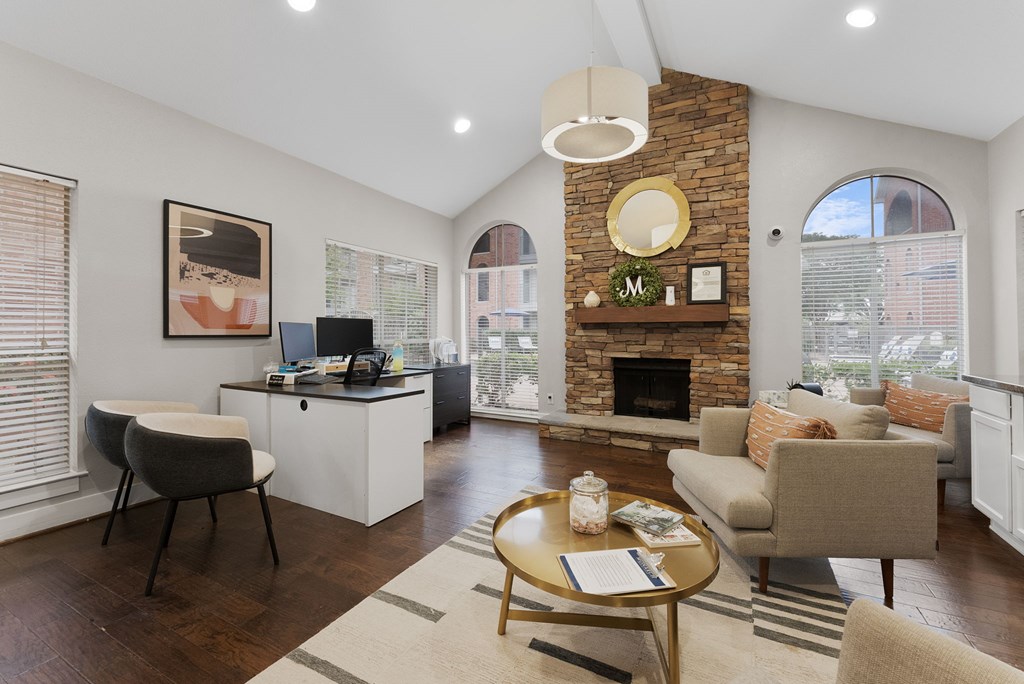 A cozy living room with a fireplace and a desk area.