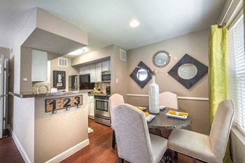 A kitchen with a table and chairs in front of it.