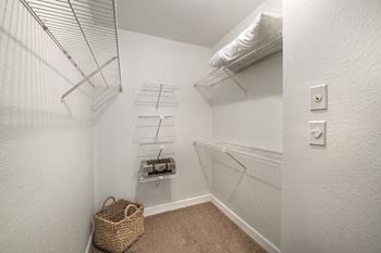 A small room with a shelf and a basket on the floor.