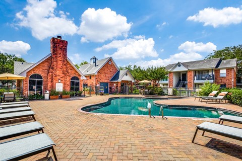 Pool area with brick clubhouse and lounge chairs at Monarch Medical Center Apartments, Texas, 77054