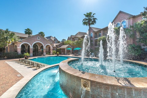 Resort style pool with fountains and lounge chairs at Melia Medical Center Apartments, Houston