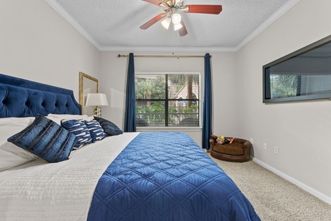 Bedroom with tufted headboard and large window at Melia Medical Center Apartments, Texas