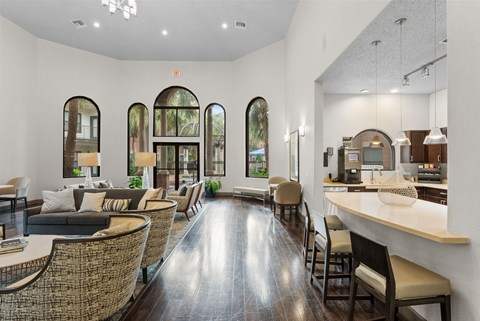 Clubhouse lounge with arched windows and kitchen area at Melia Medical Center Apartments, Houston, Texas