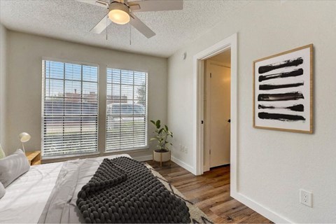 A bedroom with a large bed and a painting on the wall.