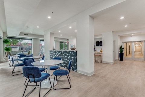 A modern dining area with blue chairs and a white table.