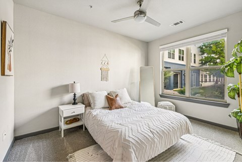 A bedroom with a large bed and a window overlooking a building.