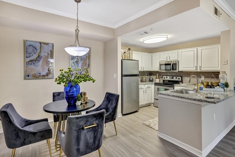 A kitchen with a table and chairs and a refrigerator.