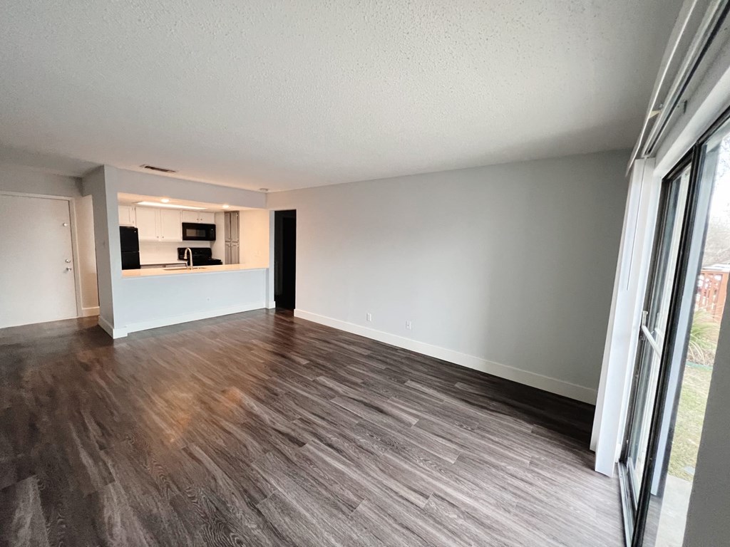 an empty living room with a large window and a kitchen at Northchase, Texas, 78753