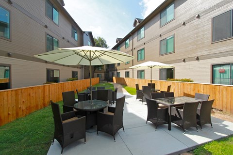 A patio with a table and chairs under an umbrella.