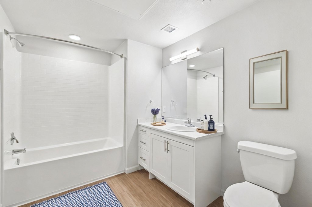 A white bathroom with a toilet, sink, and bathtub.